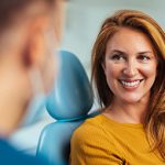 Woman sitting in dental chair and smiling at dentist in Austin Texas
