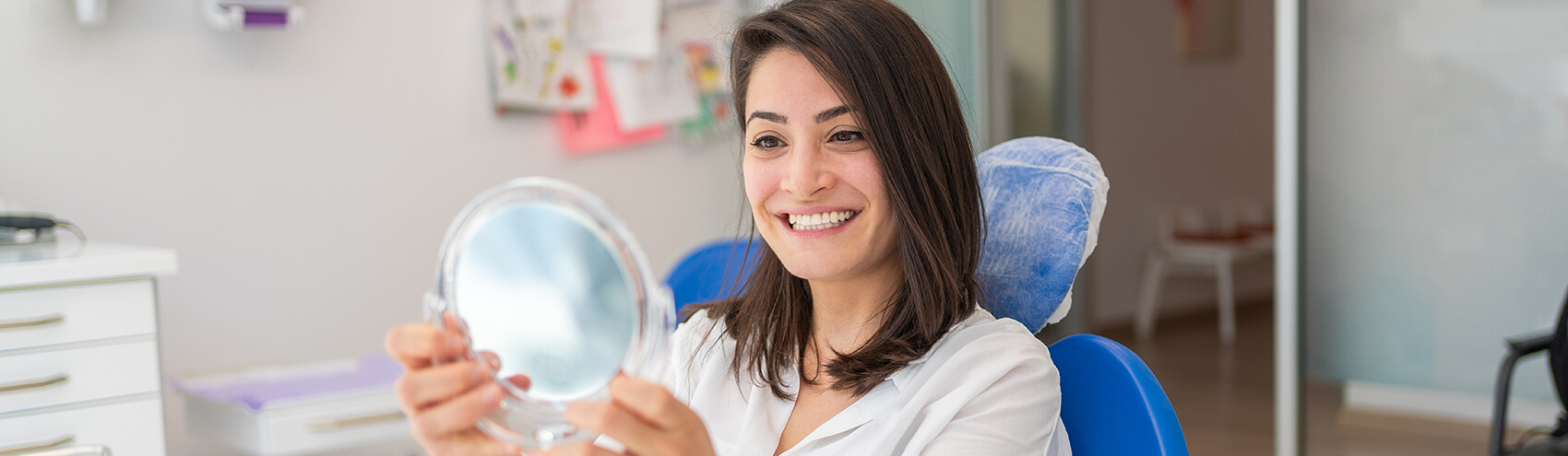 woman examining her smile in a mirror