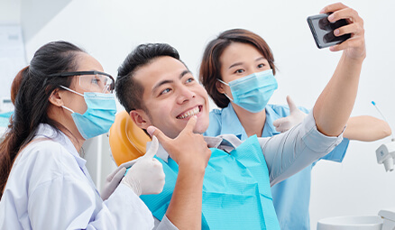 man posing for a picture with his dental hygienists