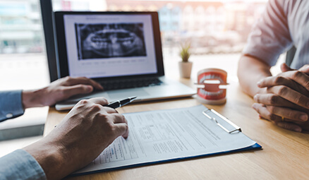 two people discussing dental-related paperwork