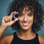 woman holding invisalign clear aligners in austin