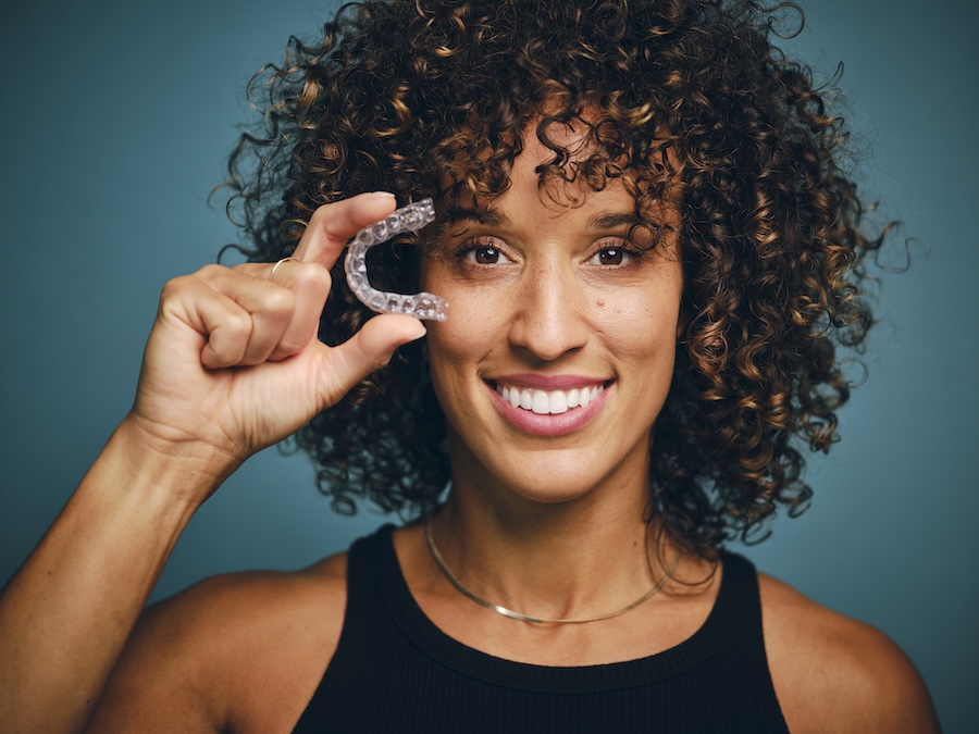 woman holding invisalign clear aligners in austin