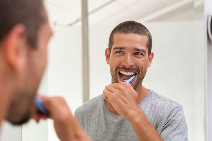 man brushing his teeth a great part of a healthy dental routine austin